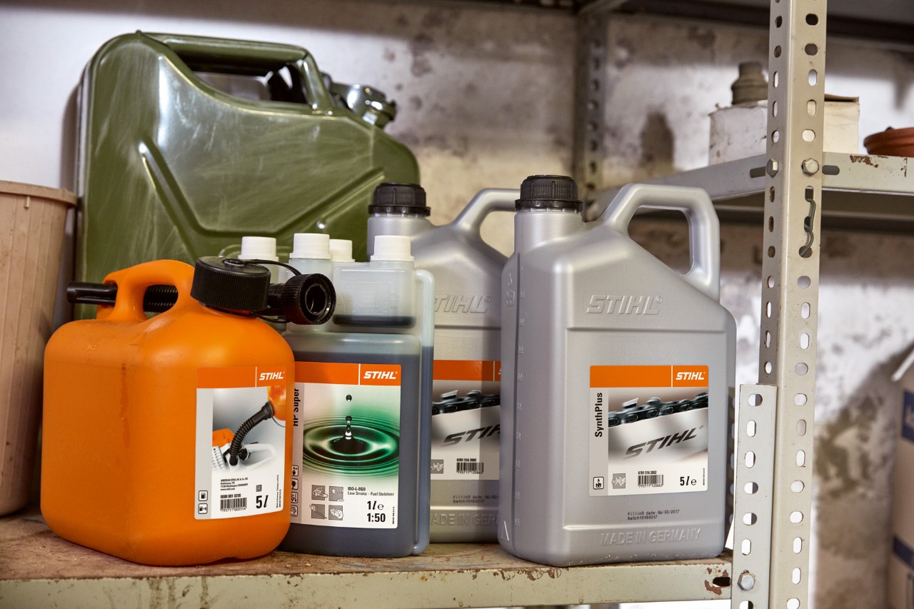 STIHL HPスーパー 2サイクルエンジン用オイルが入った明るい色の携行缶と、刈払機の混合燃料が入ったオレンジ色の携行缶