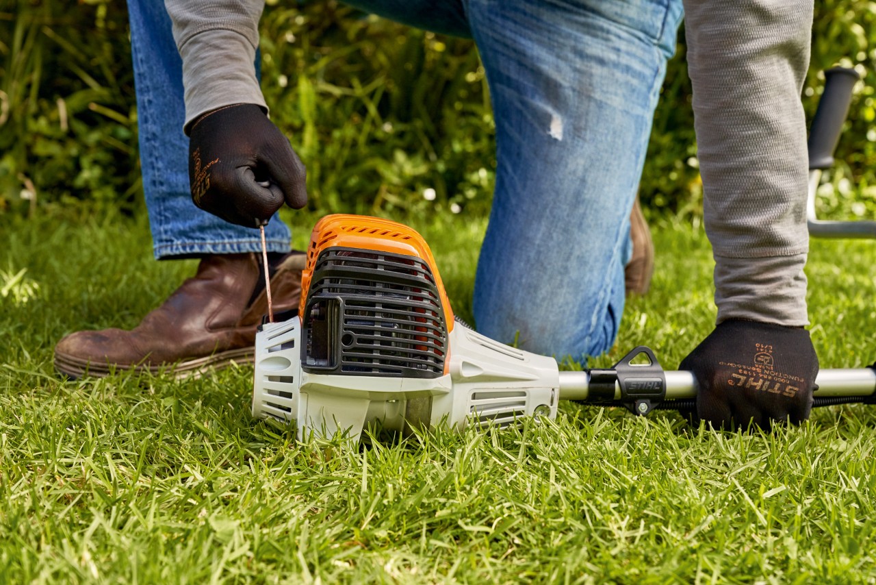 エンジン刈払機STIHL FS 91のスターターロープを引っ張っている男性 