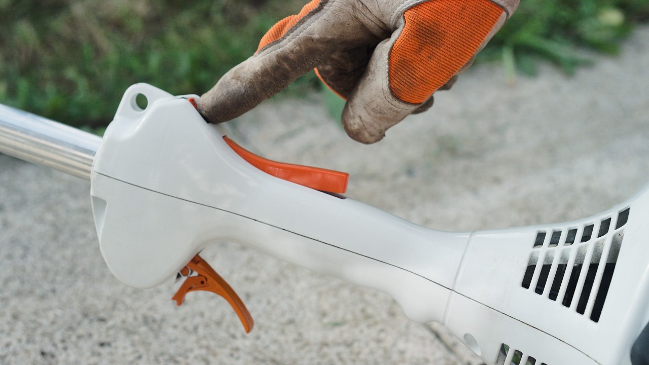 エンジン刈払機STIHL FS 38の停止スイッチを操作している様子