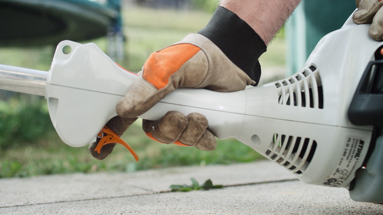 エンジン刈払機STIHL FS 38のスロットルトリガーを押している様子