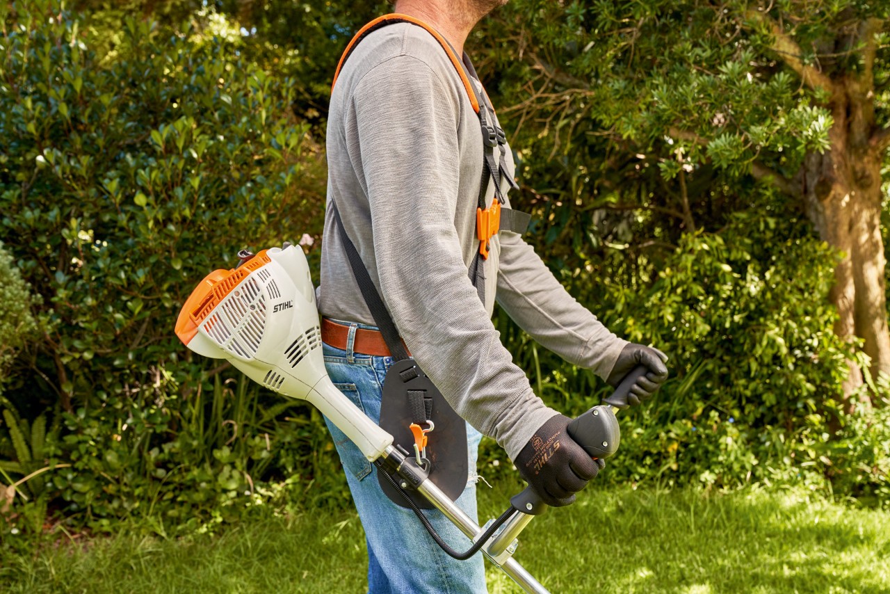 エンジン刈払機STIHL FS 56を地面から持ち上げている男性