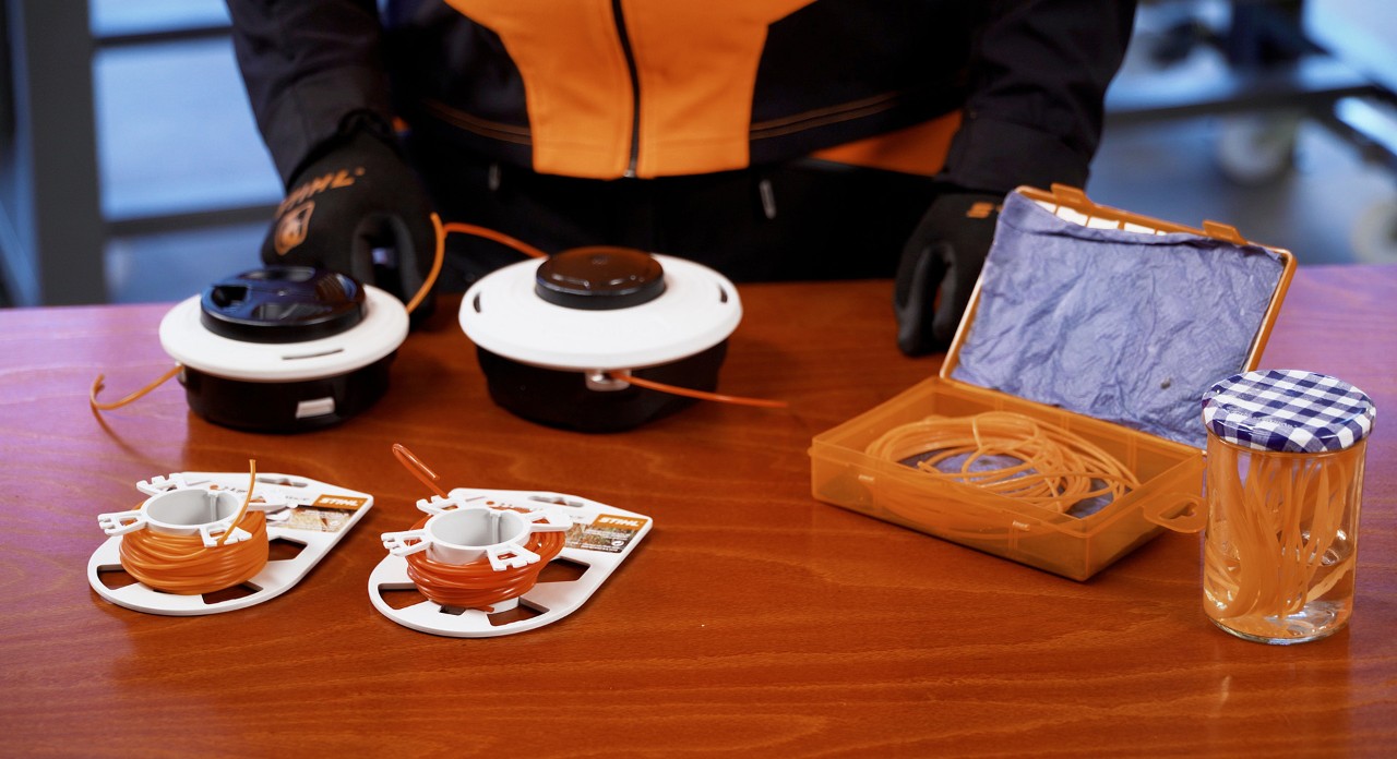 ほどかれたナイロンコードが入っているプラスチック容器、その隣にある閉じている保存瓶の中で水に浸けられているナイロンコード