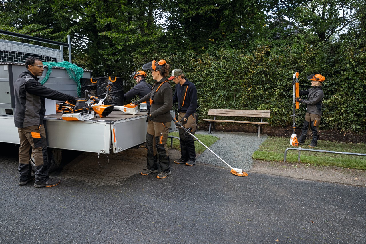 車両の荷台からSTIHL APシステムのツールと背負式バッテリーを取り出す造園業者。