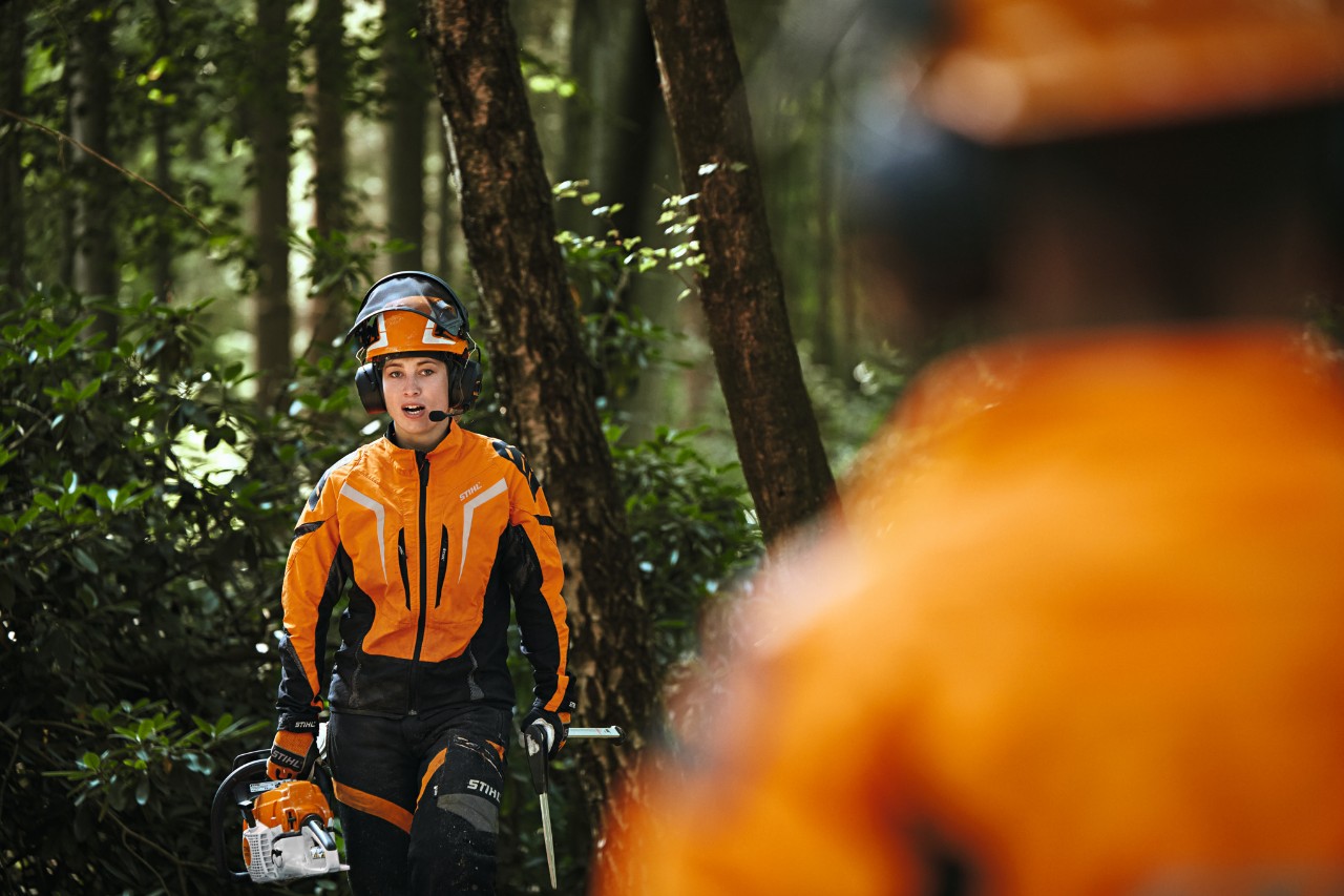 カンファレンスシステム「STIHL ADVANCE ProCOM」で作業を行うSTIHL作業用防護服を着用した2人の林業作業員 